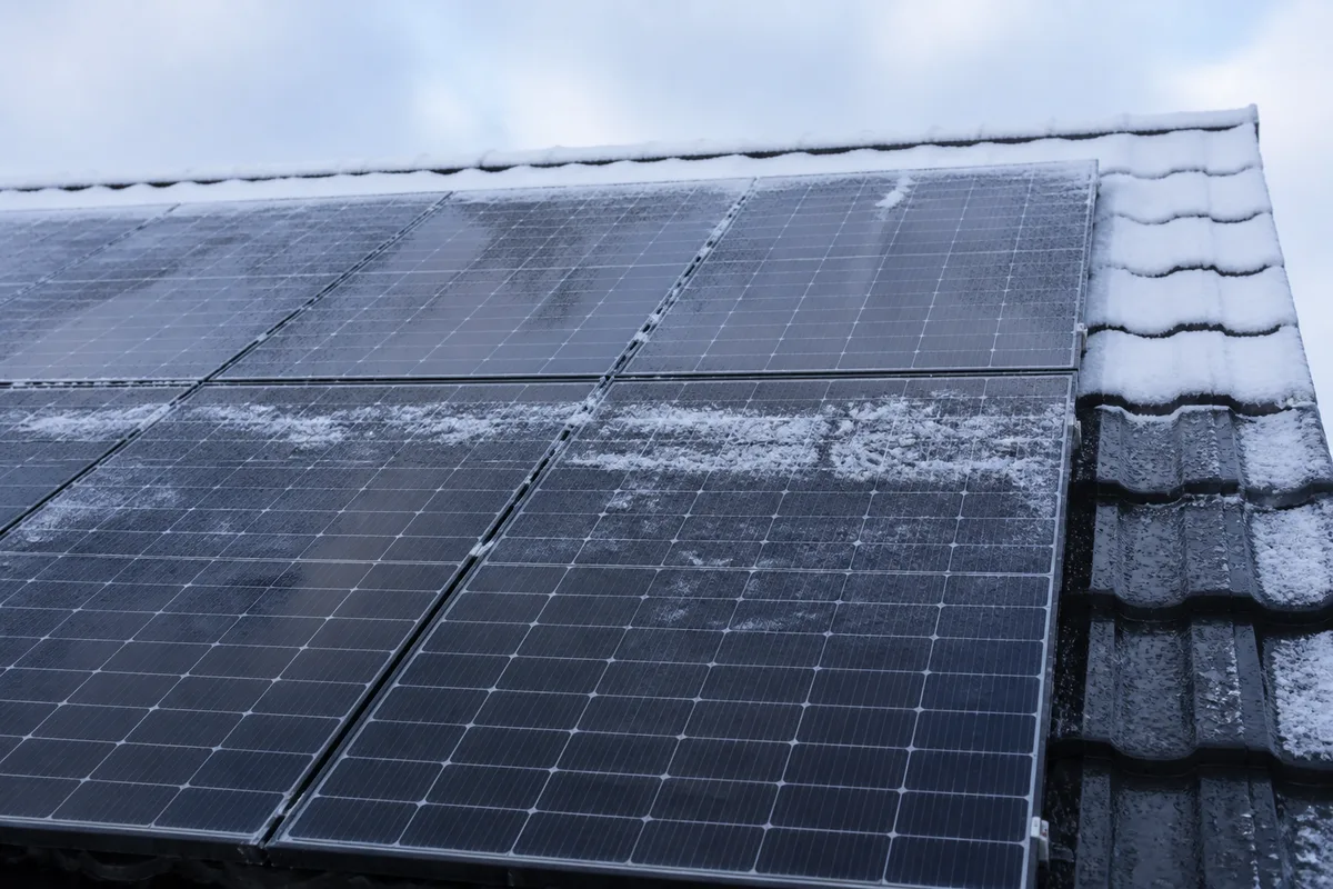 Panneaux solaires en hiver recouverts de givre sous une lumière diffuse